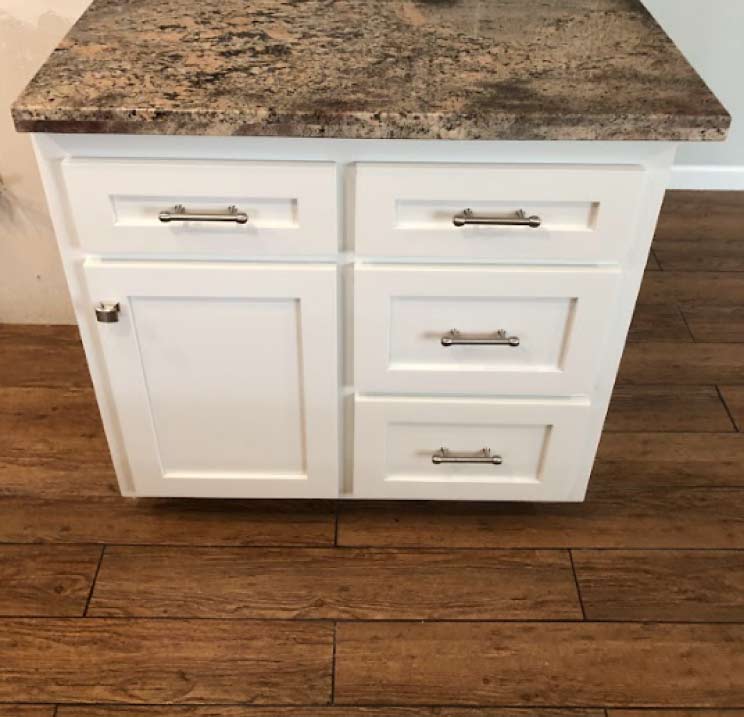 Refinished kitchen island cabinets spray-painted with bright white durable enamel demonstrating a flawless factory-finish result