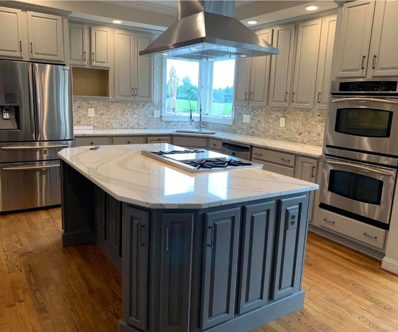 Luxury kitchen renovation featuring a custom-painted charcoal grey island and white wall cabinets with high-end stainless steel appliances in Fresno.